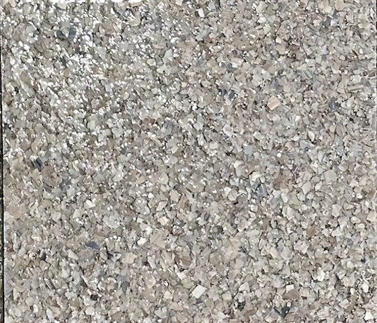 Pumice epoxy flake floor color sample with light gray, beige, cream, and muted stone-colored flakes.