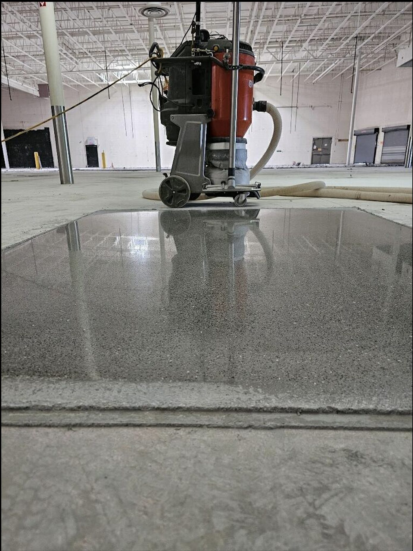 Polished concrete overlay test patch after full polish showing gloss and aggregate exposure.
