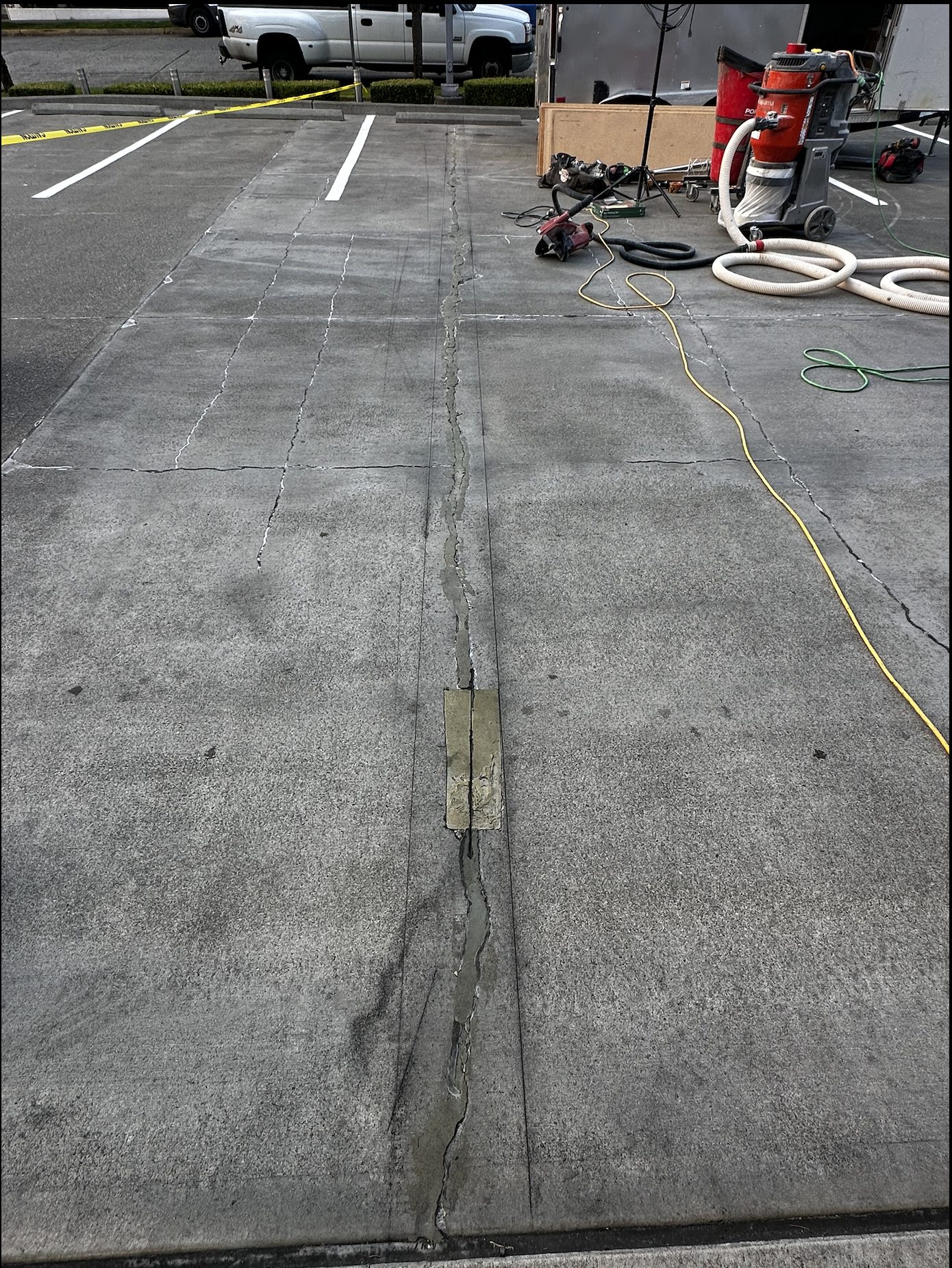Commercial parking lot concrete surface showing a cracked joint before repair and prep work.